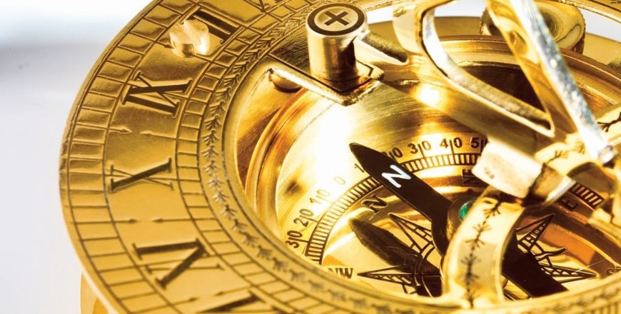 Brass compass with a detailed dial, needle pointing north, and engraved markings for navigation.