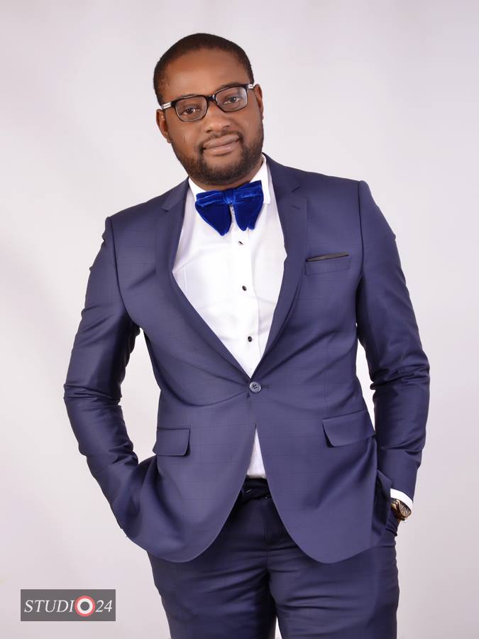 Legal professional in a suit with a bow tie, posing confidently against a neutral background.