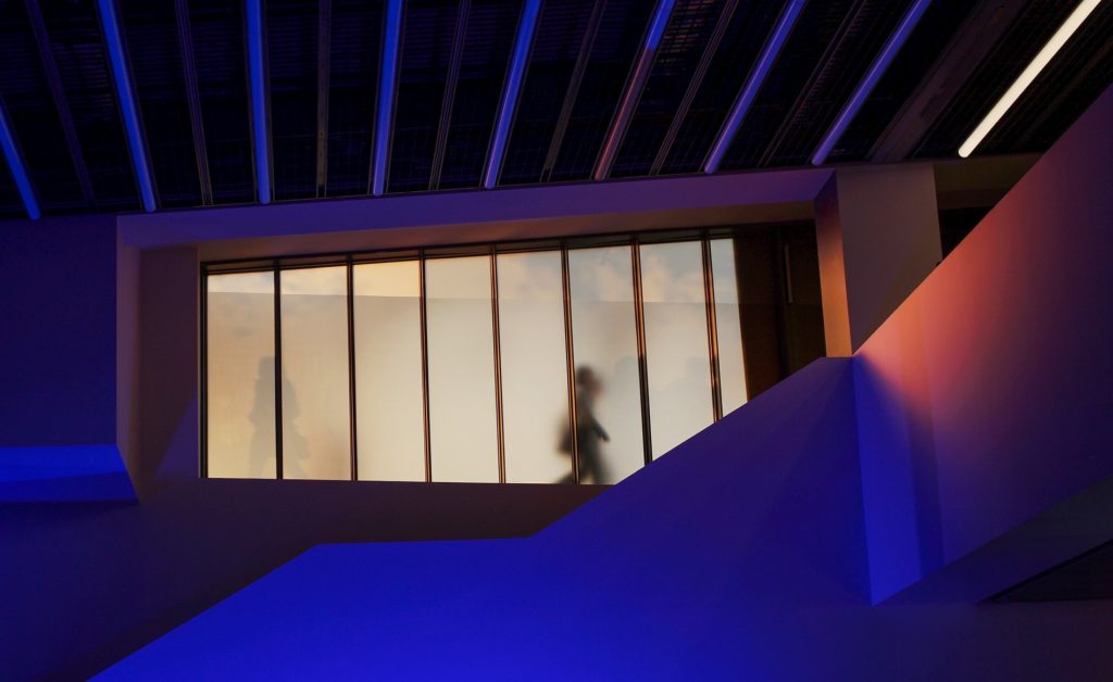 Silhouetted figures walking past a frosted window in a modern legal office environment.