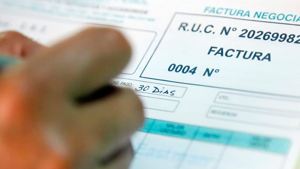 Hand writing on a financial document labeled "FACTURA," with visible columns for data entry.