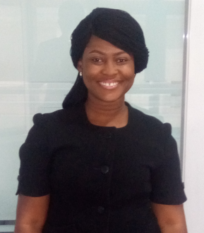 Legal professional smiling in a black suit, standing in a modern office setting.