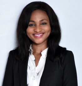 Smiling legal professional in a business suit against a plain background.
