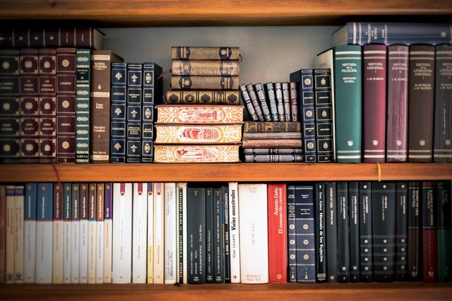 Legal books organized on a wooden shelf, featuring various titles and volumes on law and legal principles.