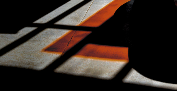 Shadow play on concrete surface with orange highlights and grid patterns, no specific legal context visible.