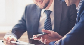 Lawyer consulting with client over tablet in modern office space.