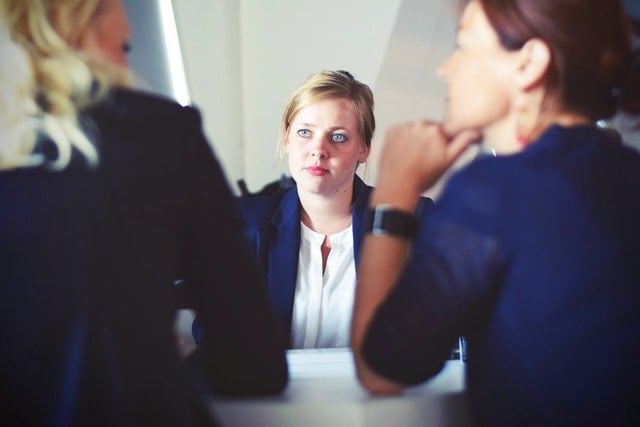 Lawyer engaging in consultation with two clients in a professional office setting.