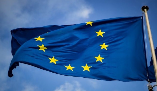 European flag waving against a blue sky backdrop.