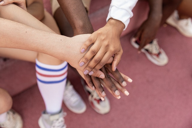 Diverse group of hands joined together, symbolizing unity and collaboration.