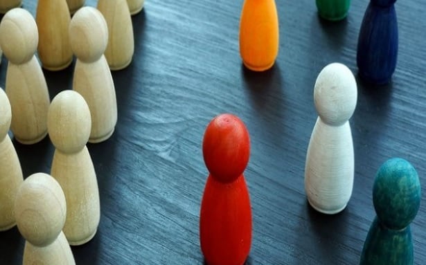Colorful wooden figurines arranged on a table, depicting a symbolic representation of different perspectives.