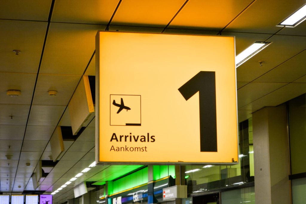 Signage displaying "Arrivals" with an airplane icon at an airport terminal.