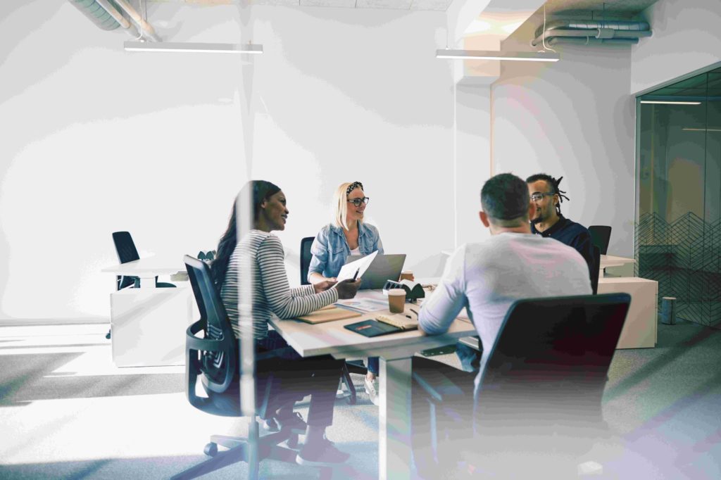 Group of professionals discussing legal strategies at a conference table in a modern office setting.