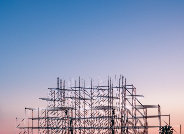 Scaffolding structure against a gradient sky at dusk, indicating construction activity.