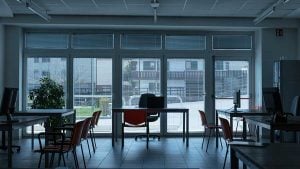 Bright, spacious law office interior with desks, chairs, and large windows overlooking an outdoor area.
