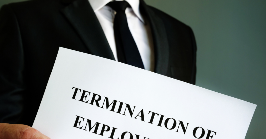 Attorney holding a document labeled "Termination of Employment" against a neutral background.