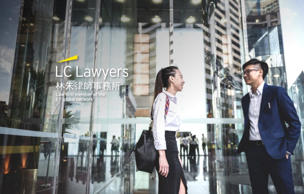 Lawyers conversing outside a modern law firm with glass entrance and urban backdrop.