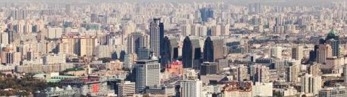 Panoramic view of a densely populated urban cityscape with tall buildings and residential areas.