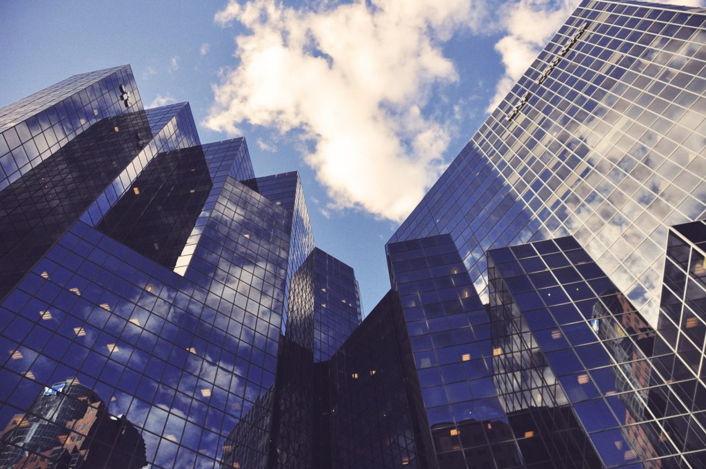 Modern office building with reflective glass facade and clear blue sky.