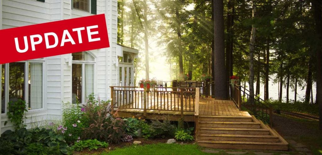 Wooden deck of a lakeside house surrounded by trees and flower beds, with "UPDATE" banner across the top.