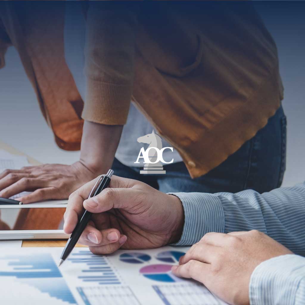 Two individuals analyzing data and charts while discussing legal strategies at a professional workspace.