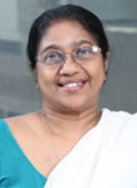 Legal professional smiling while wearing traditional attire, positioned against a modern office backdrop.