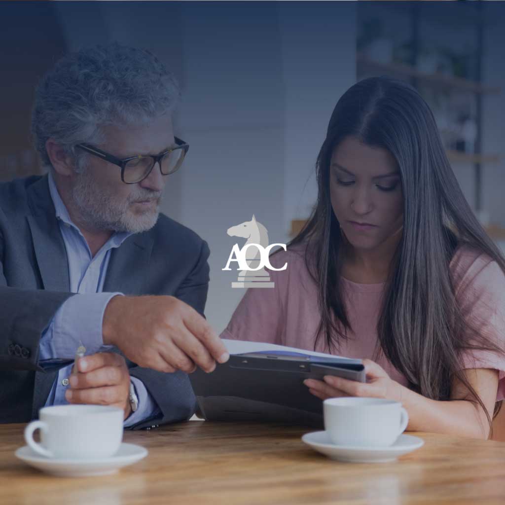 Attorney consulting with client over legal documents at a table with coffee cups in a professional setting.