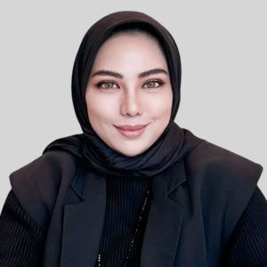 Legal professional wearing a black hijab and blazer, smiling against a neutral background.