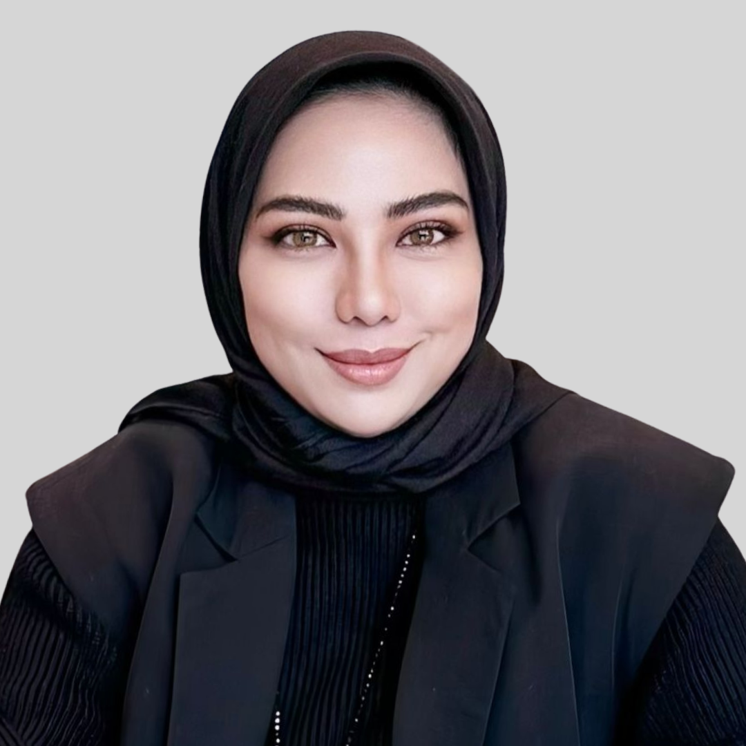 Legal professional wearing a black hijab and blazer, smiling against a neutral background.