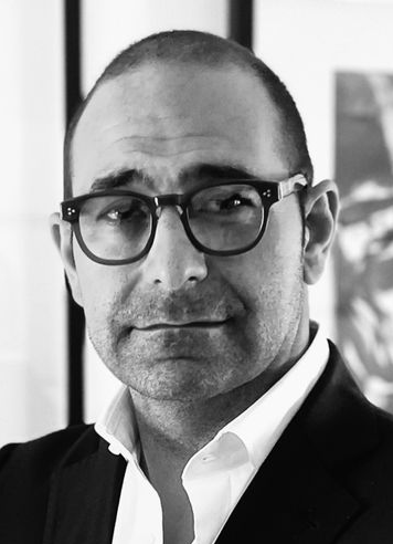 a man wearing glasses and a suit