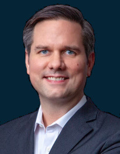 Attorney posing confidently for professional portrait against plain background.