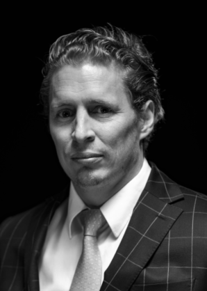 Lawyer in a suit with a serious expression against a dark background.