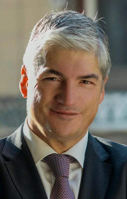 Lawyer in a suit smiling confidently, with a professional legal setting in the background.