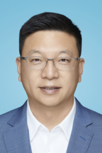 Legal professional in a blue suit with glasses against a plain blue background.