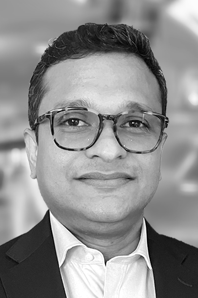 Lawyer in a suit with glasses, presenting a professional appearance in a neutral setting.