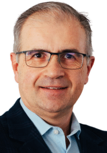 Legal professional smiling, wearing glasses and a blazer, suitable for law firm profile or attorney website.