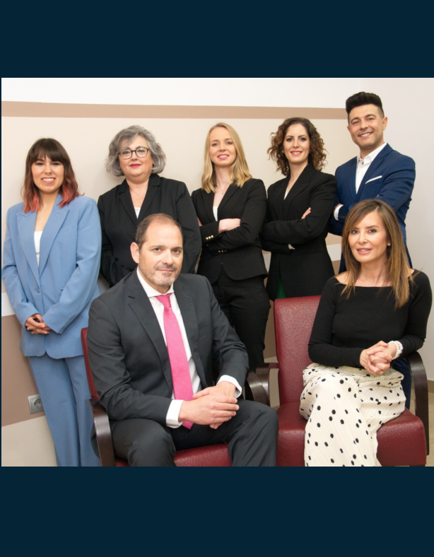 Law firm team posing for a group photo, featuring attorneys in professional attire in an office setting.