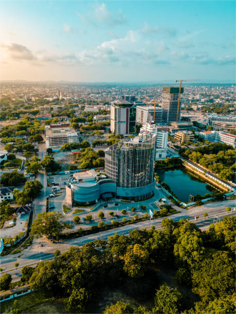 Aerial view of a modern cityscape featuring office buildings and green spaces near waterway.