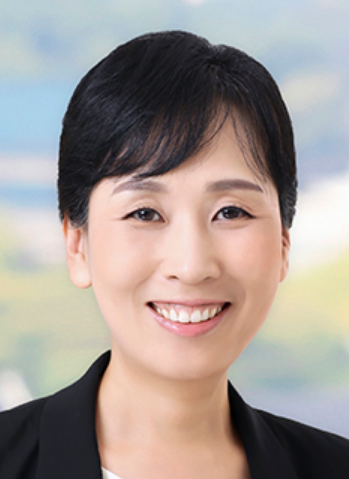 Professional woman smiling, with short black hair, dressed in blazer, suitable for legal or corporate setting.