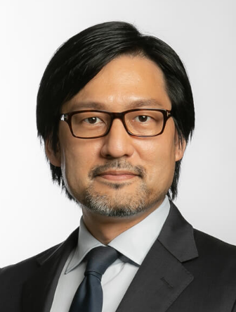 Lawyer in suit and glasses, looking directly at the camera against a neutral background.