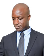 Lawyer adjusting tie while looking down, dressed in a suit against a plain background.