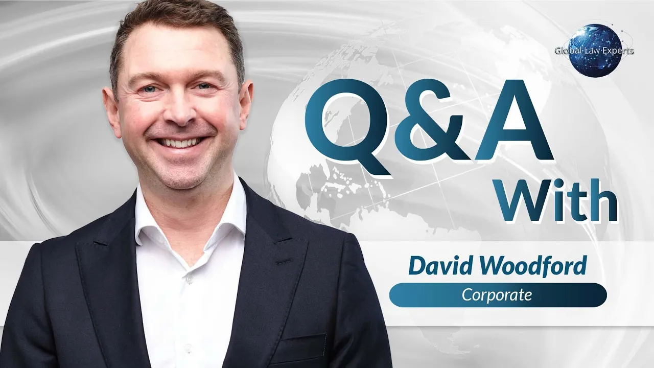 Corporate attorney smiling at the camera, featured in a Q&A graphic for Global Law Experts.