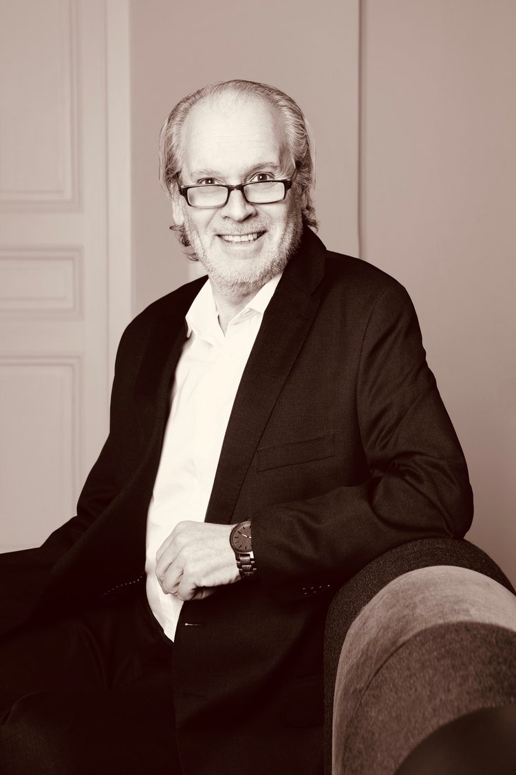 Lawyer seated casually, smiling, in a professional setting with a focus on client engagement.