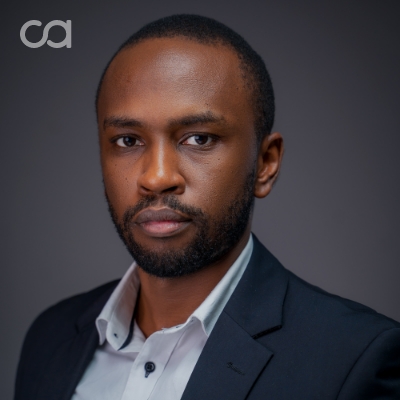Professional attorney posing for a headshot in a formal suit against a neutral background.