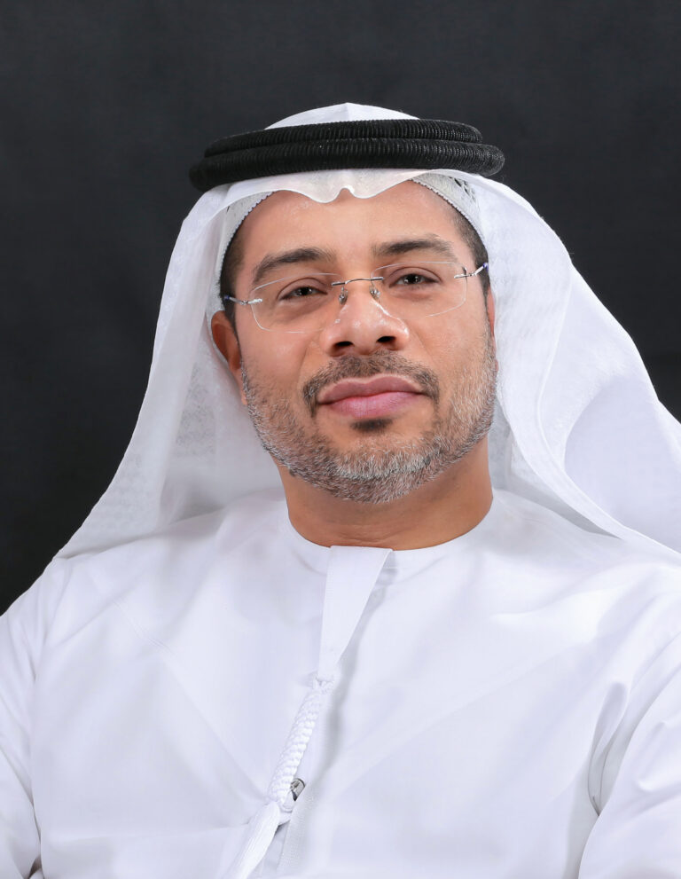Legal professional in traditional attire, facing the camera, presenting a confident expression against a dark background.