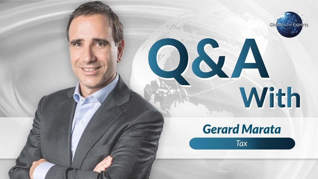 Tax attorney Gerard Marata presenting a Q&A segment, with a world map background.