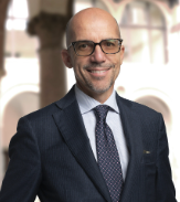 Attorney Smiling In A Formal Suit, Standing In A Sophisticated Office Environment.