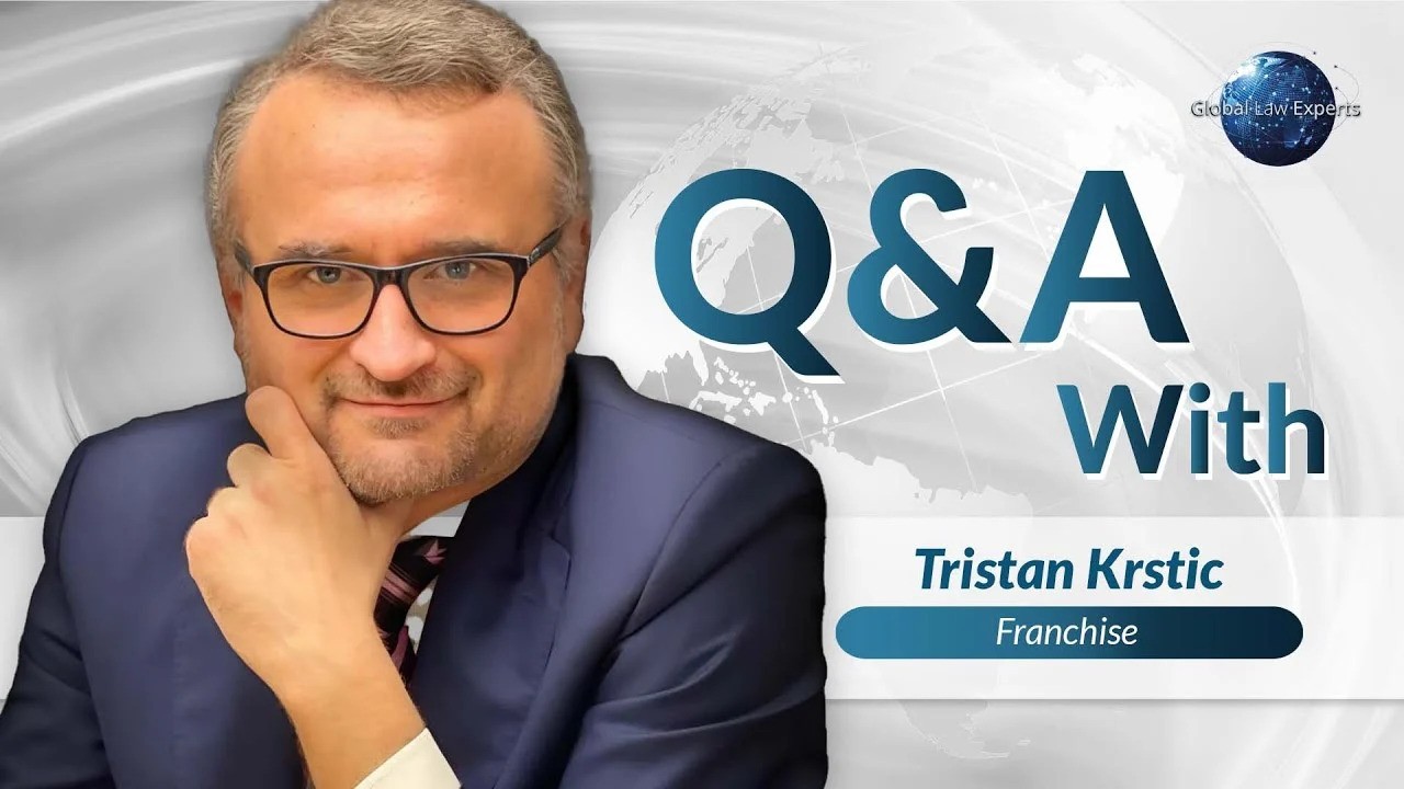 Lawyer participating in Q&A session, posing thoughtfully against a global-themed background.