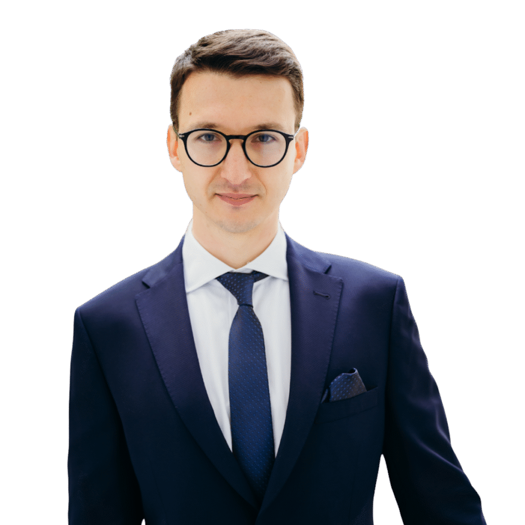 Lawyer in a navy suit and glasses posing confidently against a neutral background.