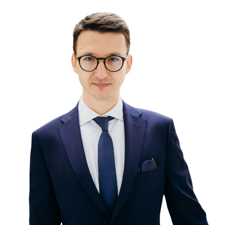 Lawyer in a navy suit and glasses posing confidently against a neutral background.