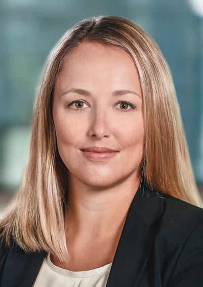 Lawyer with straight blonde hair, wearing a black blazer, in a professional headshot setting.