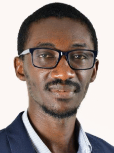 Professional man wearing glasses and a suit, looking confidently at the camera.